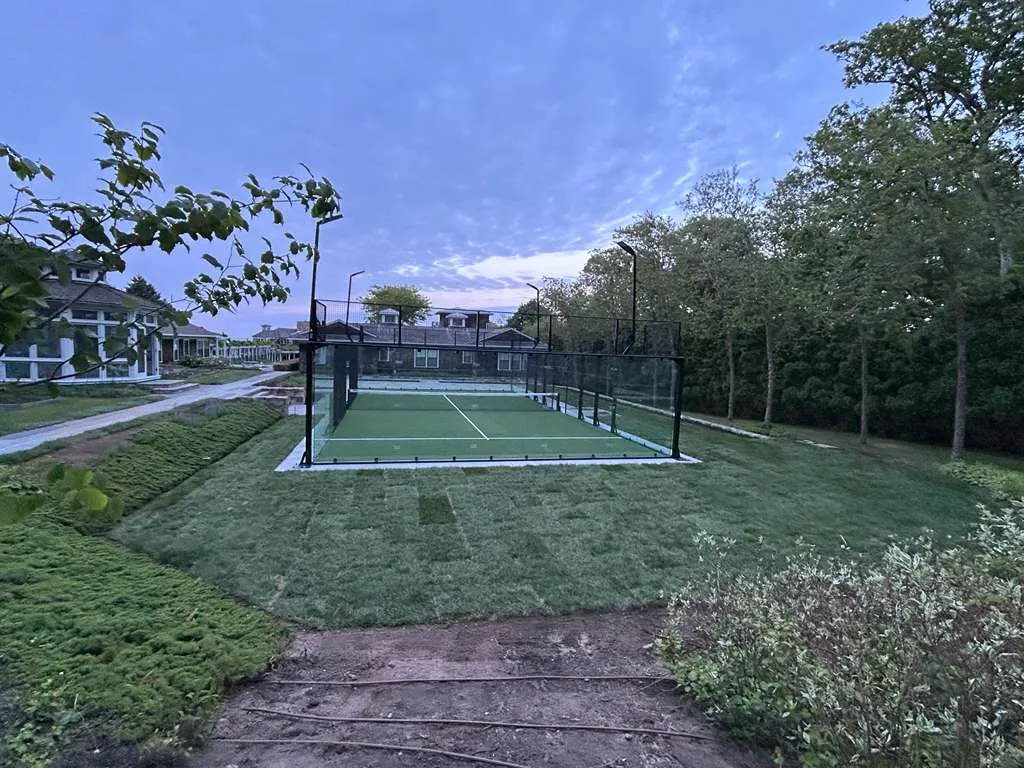 Residential padel court with LED lights at dusk on Martha's Vineyard, Massachusetts